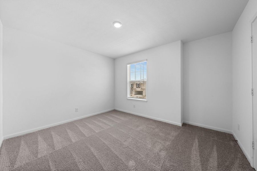 Carpeted spare room with baseboards