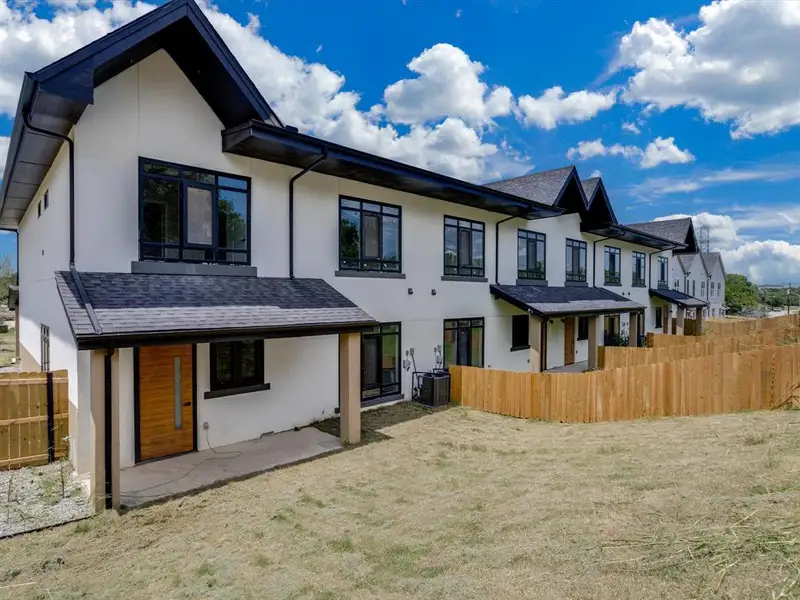 Modern townhome row featuring white stucco exteriors with dark trim Modern townhome row featuring white stucco exteriors with dark trim