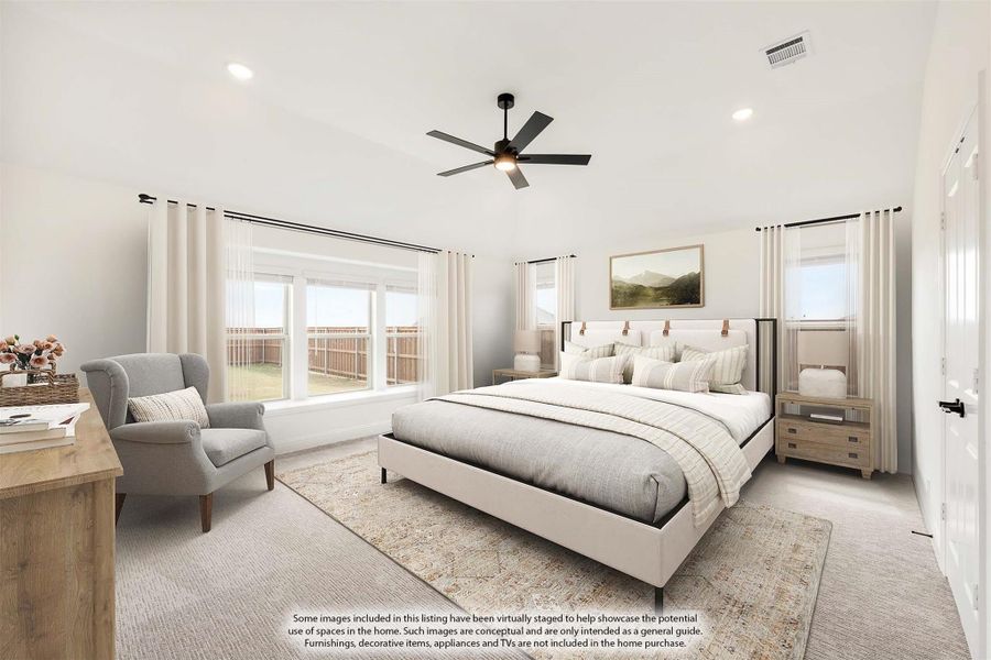 Spacious master bedroom with ceiling fan, large windows, neutral carpet, and sitting area near natural light.
