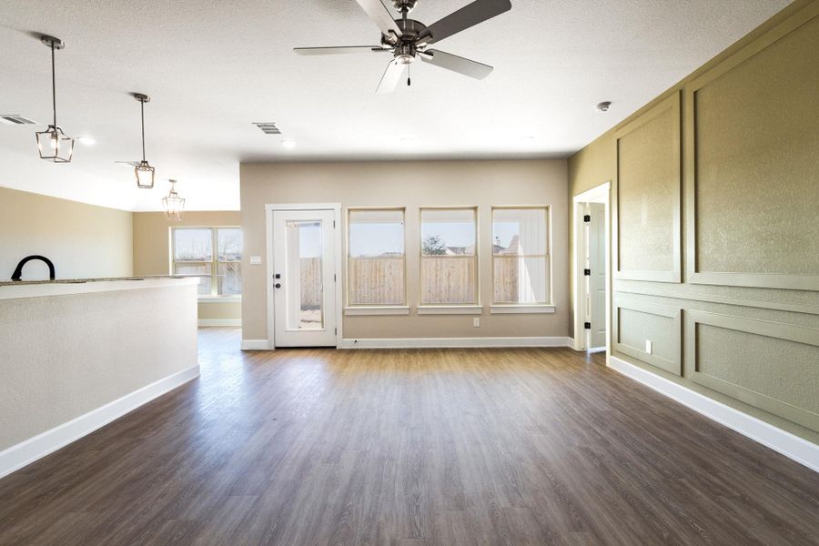 Entryway with ceiling fan, dark wood-style flooring, and a decorative wall