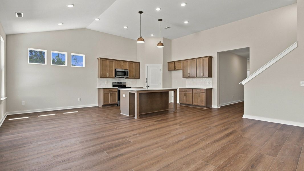 Open concept first floor with hard-surface flooring throughout the kitchen, dining, and living room areas