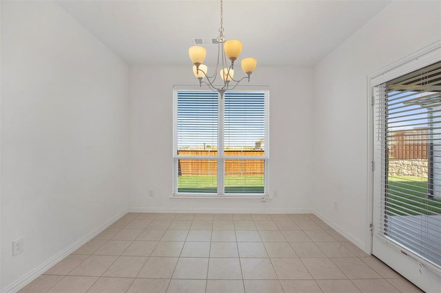 Tiled empty room with a notable chandelier