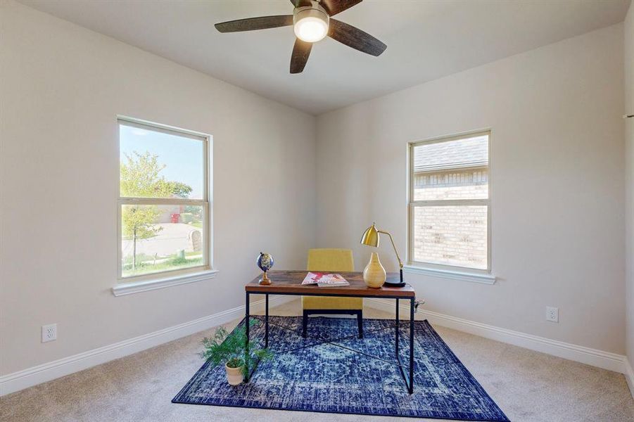 Carpeted office featuring ceiling fan