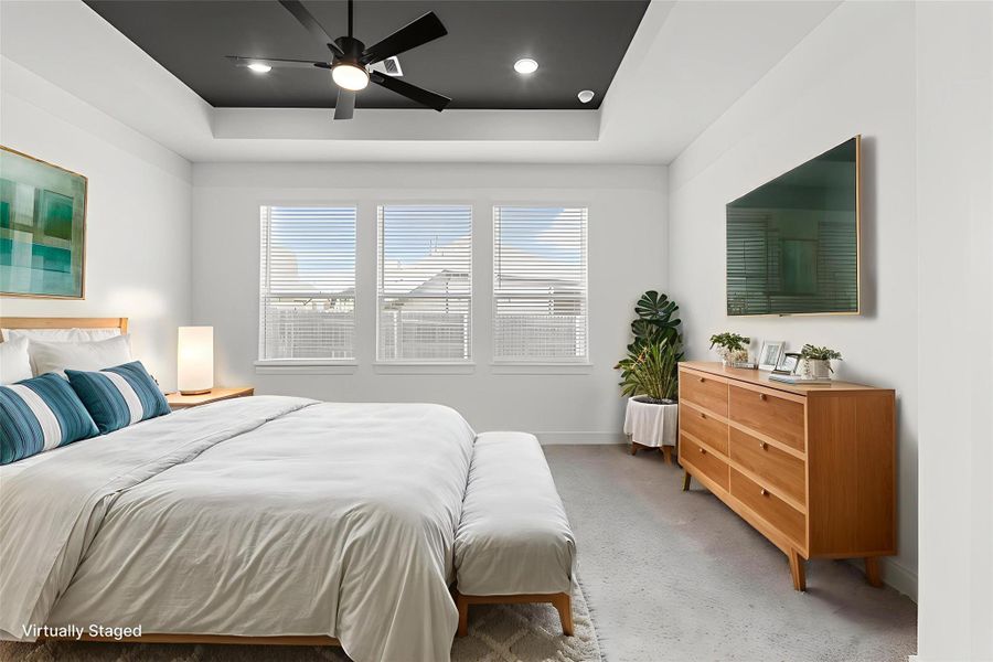 ELEGANT PRIMARY SUITE WITH ACCENT CEILING, LARGE WINDOWS, AND ROOM FOR A SEATING AREA. ELEGANT PRIMARY SUITE WITH ACCENT CEILING, LARGE WINDOWS, AND ROOM FOR A SEATING AREA.