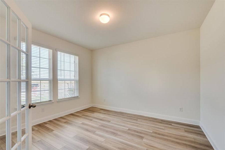 Unfurnished room with light wood-style flooring and baseboards