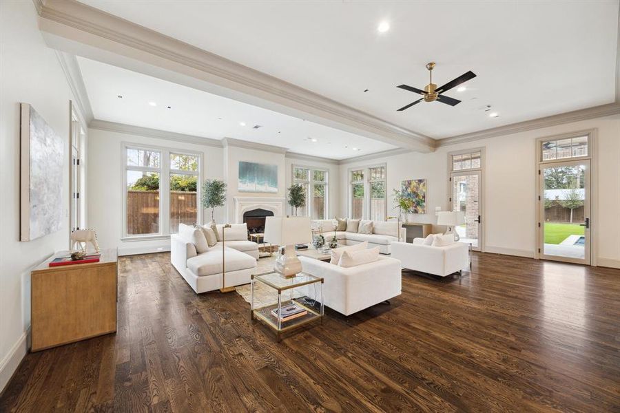 Located at the end of the grand entry hallway, this bright and spacious great room is flooded with natural light from walls of windows and French doors leading to the backyard.