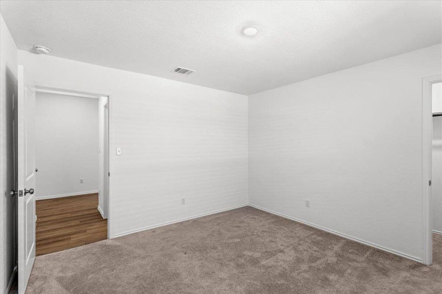 Empty room featuring dark carpet and a smoke detector