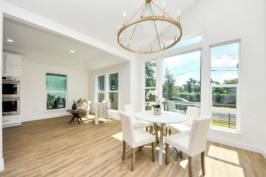 A sleek modern chandelier sets the tone for both casual dinners and special celebrations. Gather around the table as golden sunlight pours in through expansive window. The open layout flows effortlessly into a cozy sitting area—ideal for lingering conversations, entertaining guests, or enjoying quiet moments with family.