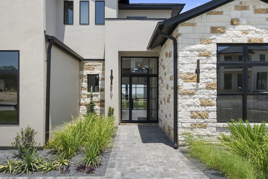 Front exterior of a new home in Milky Way at River Place, Austin, TX, highlighting curb appeal (Image 26). Front exterior of a new home in Milky Way at River Place, Austin, TX, highlighting curb appeal (Image 26).