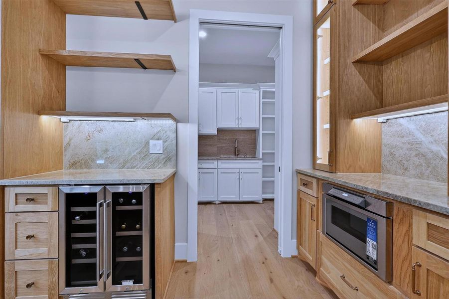 Custom cabinetry, sleek countertops, and refined finishes elevate this practical space.