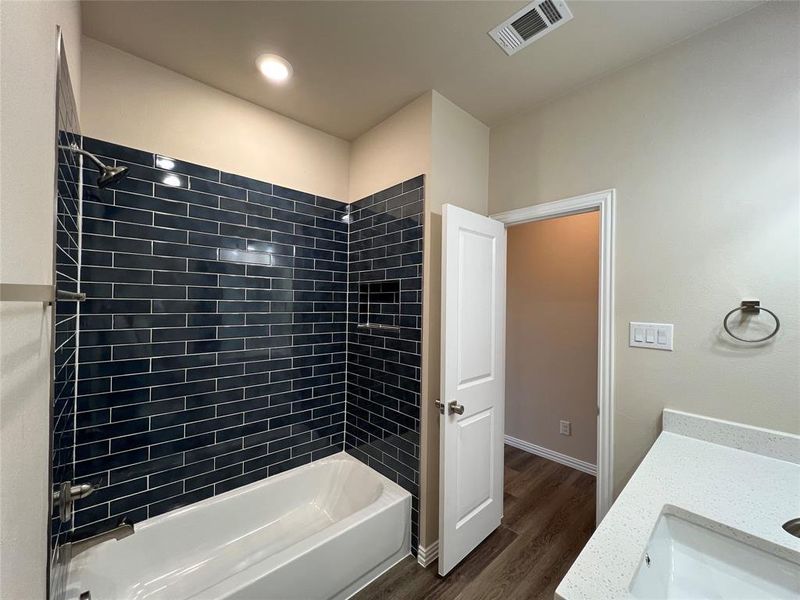 Hall Bathroom with vanity, wood-type flooring, and tiled shower / bath combo