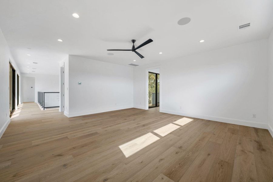 Empty room featuring ceiling fan, light wood finished floors, and recessed lighting