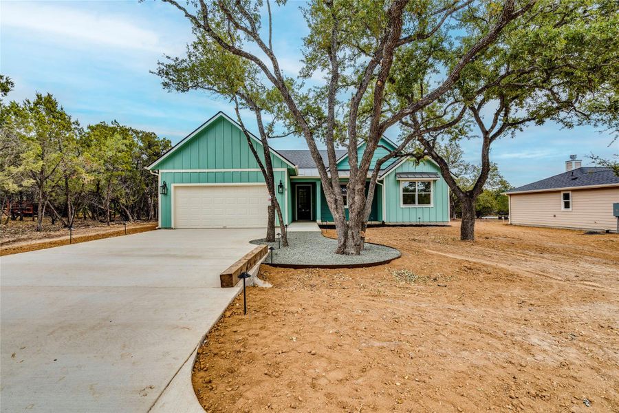 View of front of house featuring board and batten siding, driveway, and an attached garage