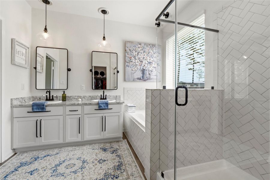 Relax and unwind in a luxurious retreat complete with a soaking tub, oversized walk-in shower, and timeless tilework.