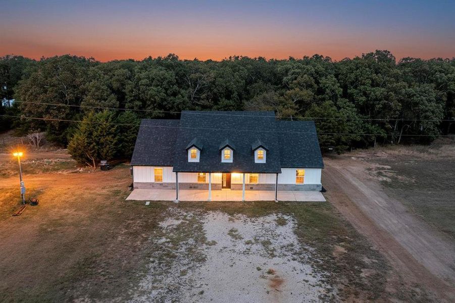 View of front of property with driveway and a front lawn