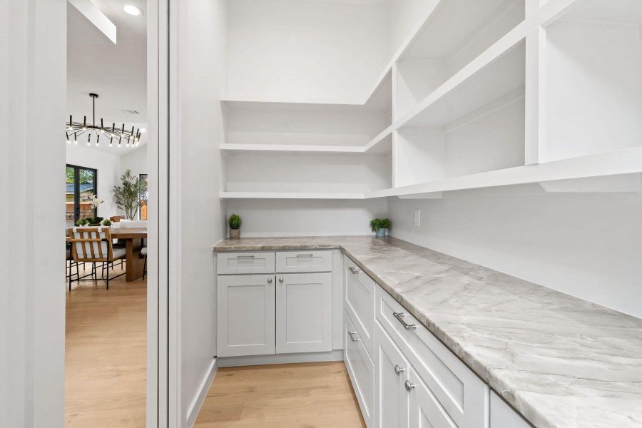 Functional pantry featuring ample shelving and a spacious countertop, perfect for kitchen organization. Functional pantry featuring ample shelving and a spacious countertop, perfect for kitchen organization.