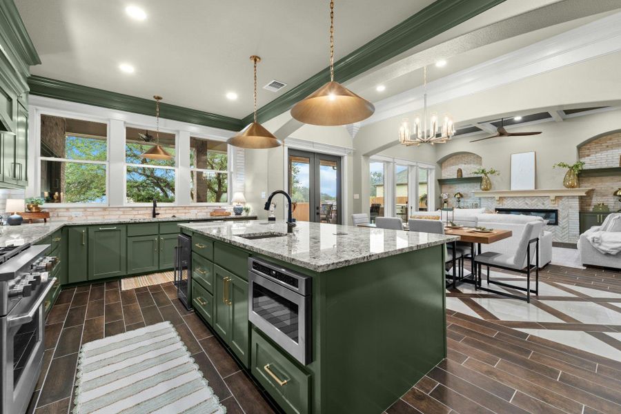 Open-concept kitchen featuring olive green cabinetry, granite countertops, and stainless steel appliances