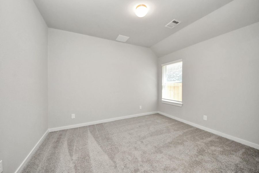Secondary bedroom features plush carpeting, large windows that let in plenty of natural light, bright paint, and spacious closets. Sample photo of completed home with similar floor plan. Actual colors and selections may vary.