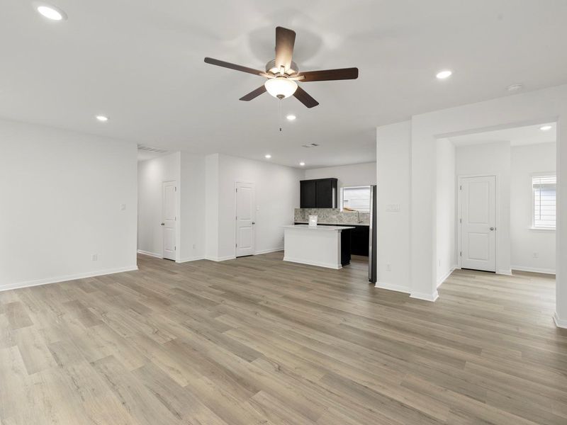 An open floorplan living area flows seamlessly into a modern kitchen, creating an inviting entertainment space.