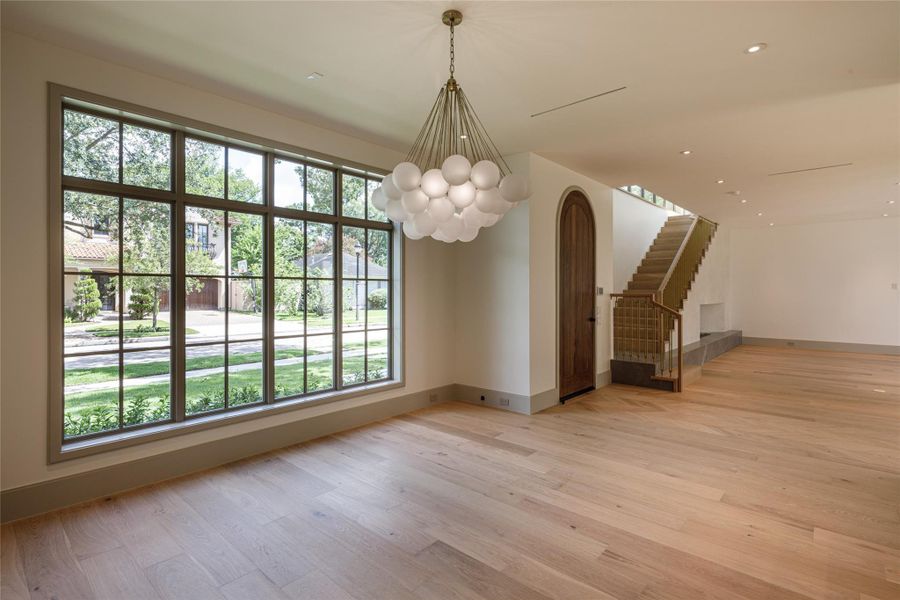 An extraordinary wall of divided-light windows brings the mature trees and established neighborhood straight into the dining space, while a sculptural chandelier gives the room its finishing note.