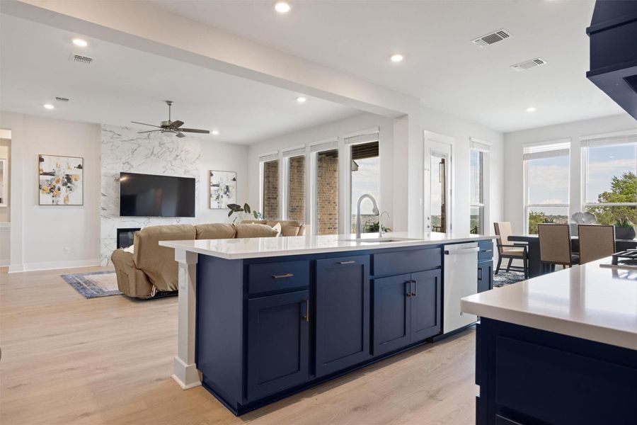 Oversized counter island with quartz countertops and elegant blue cabinetry Oversized counter island with quartz countertops and elegant blue cabinetry