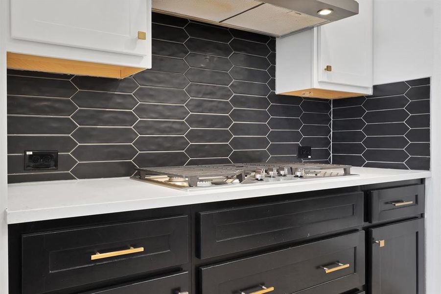 Backsplash, wall chimney range hood, and stainless steel gas stovetop