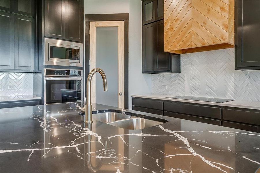 Kitchen featuring backsplash, stainless steel appliances, and sink