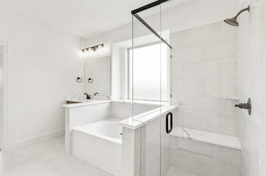 White master bathroom with soaking tub, glass walk-in shower, single vanity, and black fixtures White master bathroom with soaking tub, glass walk-in shower, single vanity, and black fixtures