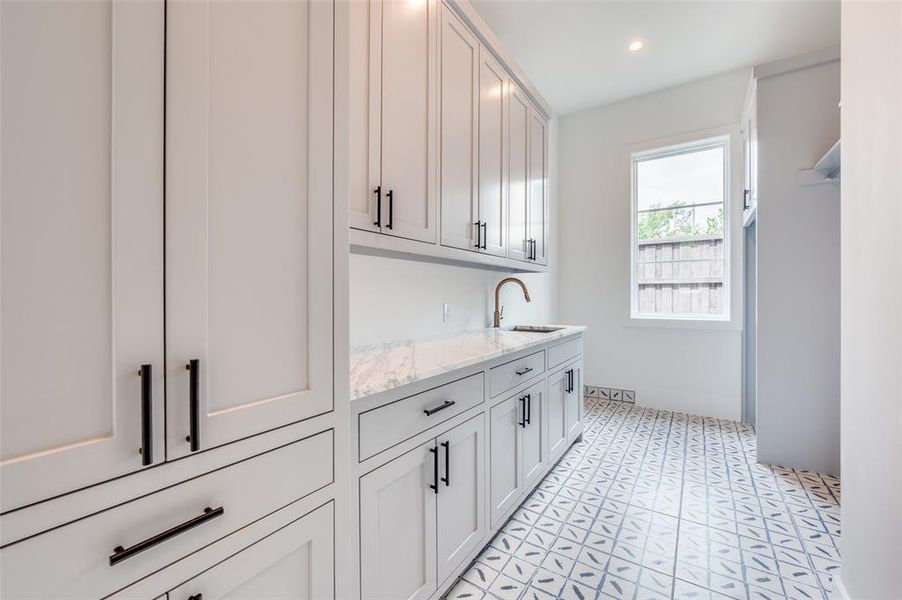 Washroom with sink and light tile patterned floors