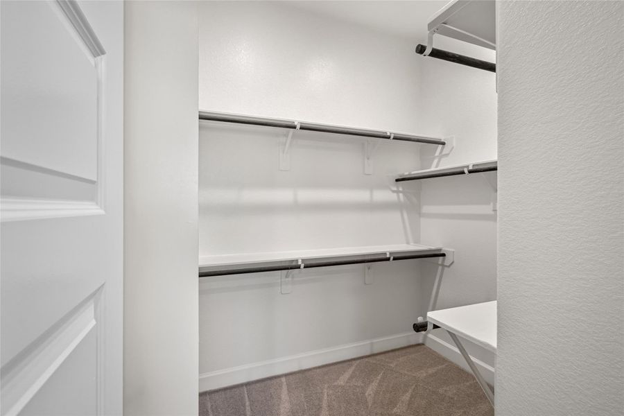 Walk-in Closet 1: Large, organized closet space with built-in shelving (one of two in the Primary Suite).