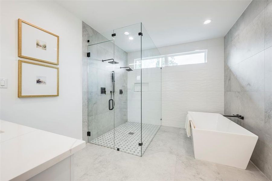 Bathroom featuring a freestanding bath, a shower stall, vanity, tile walls, and recessed lighting Bathroom featuring a freestanding bath, a shower stall, vanity, tile walls, and recessed lighting