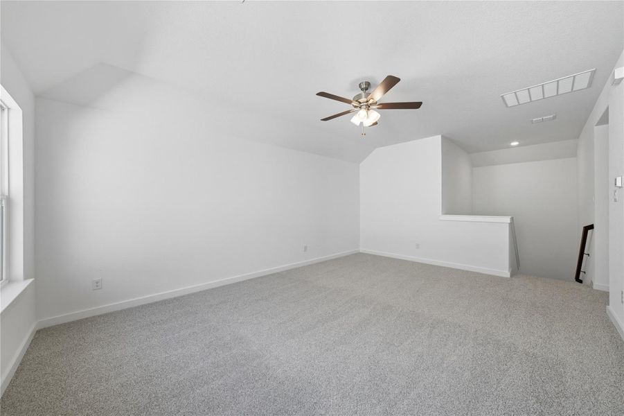 Bonus room with lofted ceiling, light carpet, and ceiling fan Bonus room with lofted ceiling, light carpet, and ceiling fan