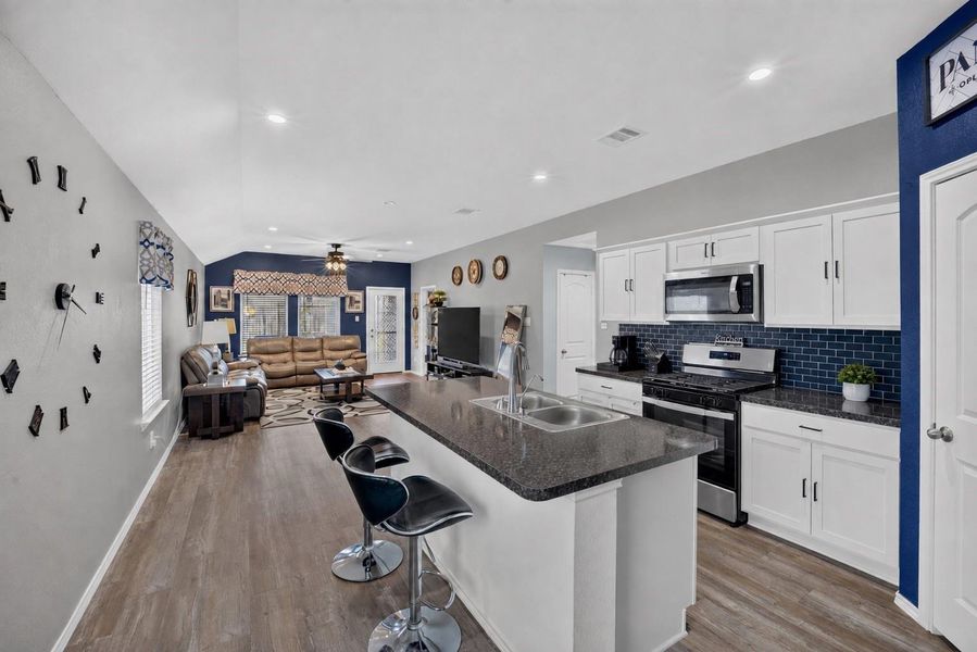 Bright, open kitchen featuring Shaker-style cabinetry, stainless steel appliances, generous counter space and an island overlooking the main living area. Bright, open kitchen featuring Shaker-style cabinetry, stainless steel appliances, generous counter space and an island overlooking the main living area.
