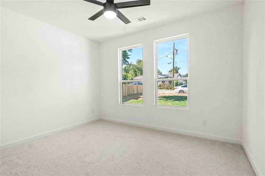 Spare room featuring light carpet and ceiling fan