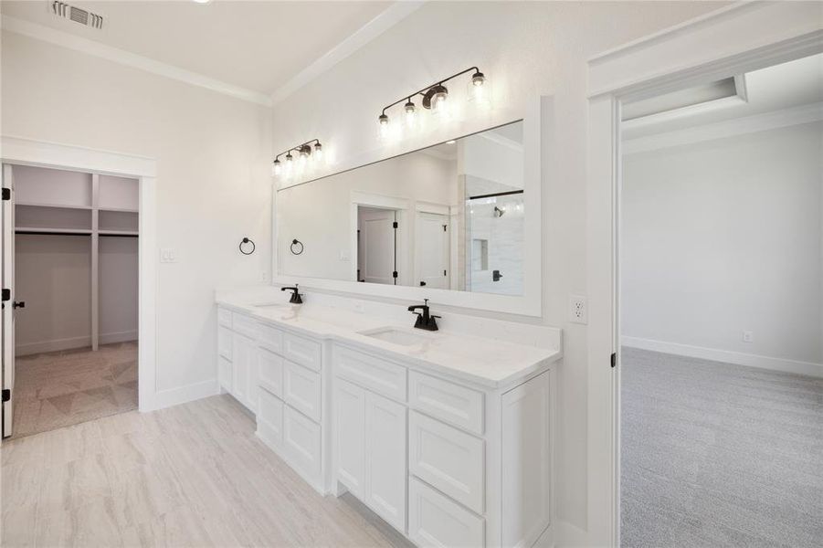 Bathroom featuring double sink vanity and crown molding