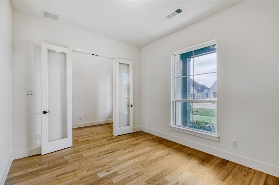 Unfurnished bedroom with light wood-style flooring and french doors