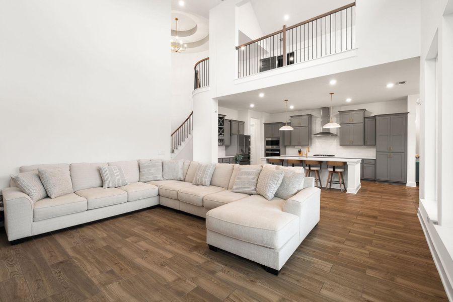 A spacious, open-concept interior unites living and culinary zones beneath soaring ceilings and an elegant upper-level balcony.