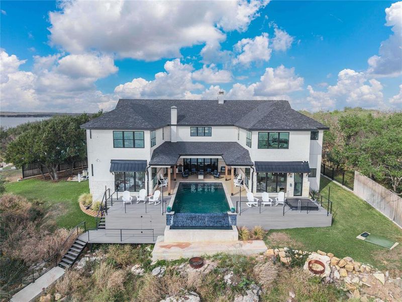Back of house with a standing seam roof, a patio area, a metal roof, roof with shingles, and outdoor lounge area