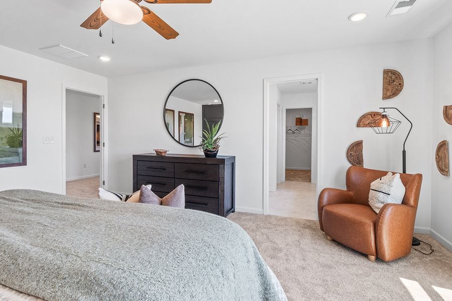 A bedroom with a bed and a chair.