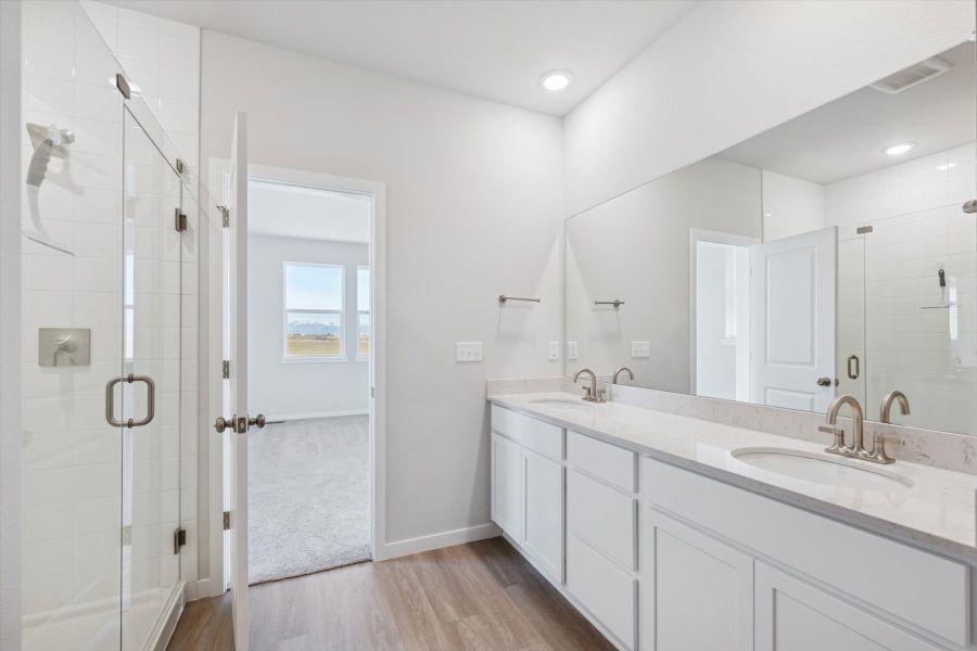A bathroom with a sink and a shower unit.