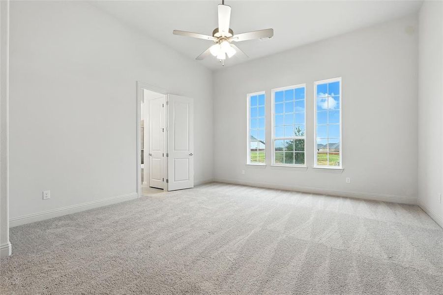 Spare room featuring light colored carpet and a ceiling fan