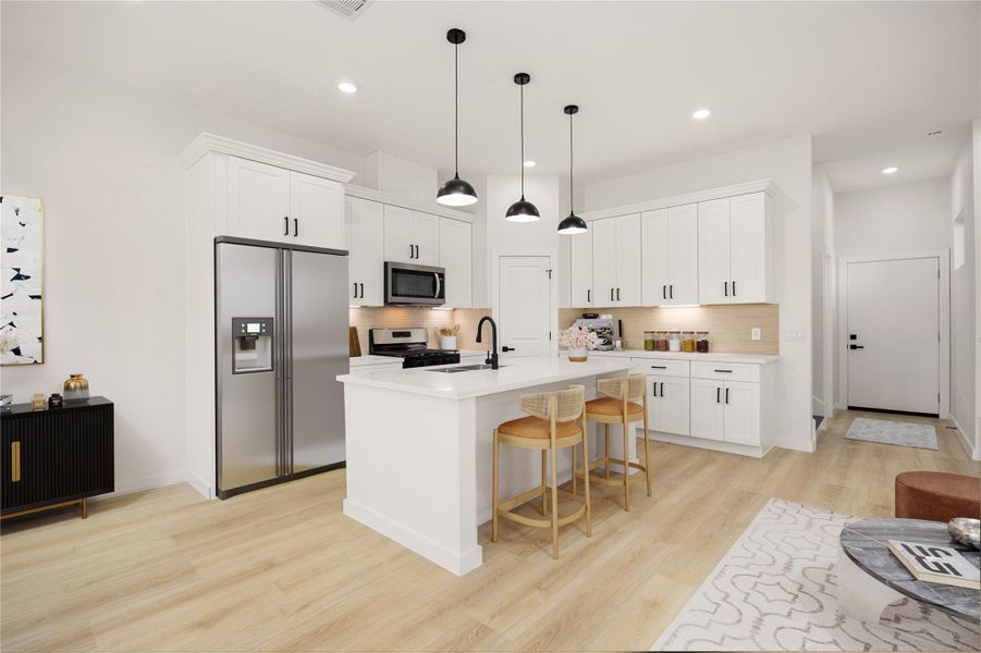 Bright, modern kitchen with white cabinetry, stainless steel appliances, and a spacious island with seating. Features include high ceilings, recessed and pendant lighting, ample counter space, and a walk-in pantry. *Virtually Staged Bright, modern kitchen with white cabinetry, stainless steel appliances, and a spacious island with seating. Features include high ceilings, recessed and pendant lighting, ample counter space, and a walk-in pantry. *Virtually Staged