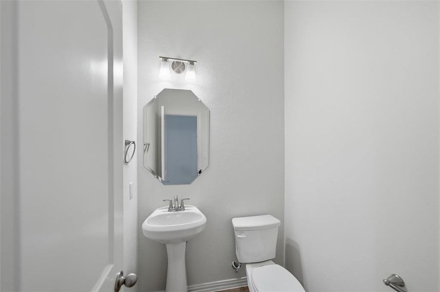 Half bath with toilet and baseboards