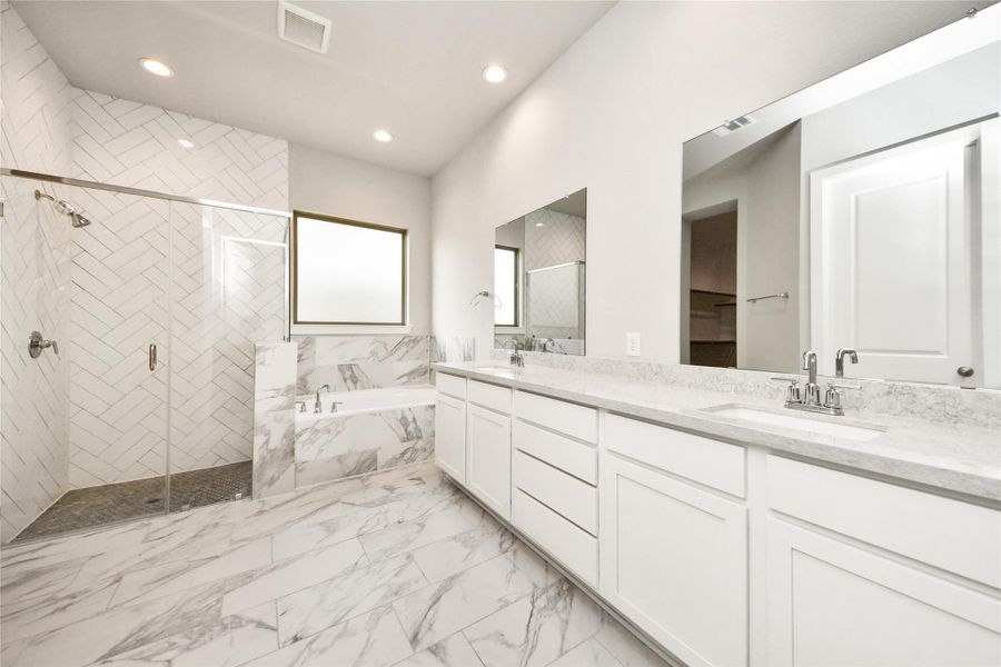 Primary bathroom with dual vanities and modern finishes