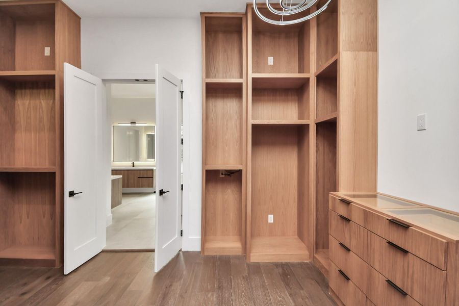 Step into luxury with this exquisite master closet, featuring custom-built white oak cabinetry that exudes elegance and sophistication. With ample storage space and thoughtful design, it's a haven for organization and style. Buyers have the opportunity to customize shelving and racks to their liking, ensuring every detail is tailored to their unique preferences. Also connected to this space is the utility room for added convenience. Step into luxury with this exquisite master closet, featuring custom-built white oak cabinetry that exudes elegance and sophistication. With ample storage space and thoughtful design, it's a haven for organization and style. Buyers have the opportunity to customize shelving and racks to their liking, ensuring every detail is tailored to their unique preferences. Also connected to this space is the utility room for added convenience.