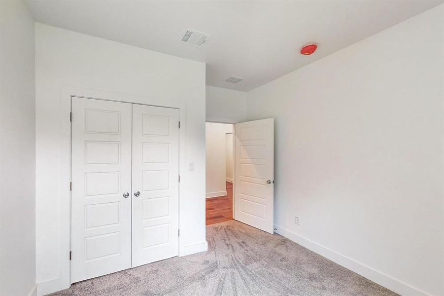 Unfurnished bedroom with a closet and light carpet