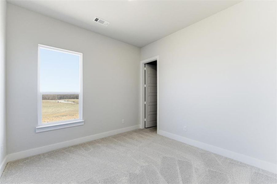 Carpeted spare room with baseboards