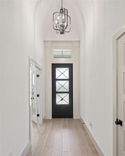 Entrance foyer with a chandelier and light wood-style floors Entrance foyer with a chandelier and light wood-style floors