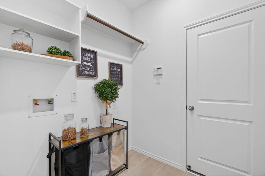 This photo shows a well-organized laundry room. It features open shelving and a rod for hanging clothes. This photo shows a well-organized laundry room. It features open shelving and a rod for hanging clothes.