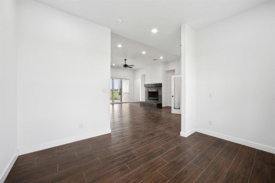 Unfurnished living room featuring a fireplace, dark wood finished floors, recessed lighting, and a ceiling fan